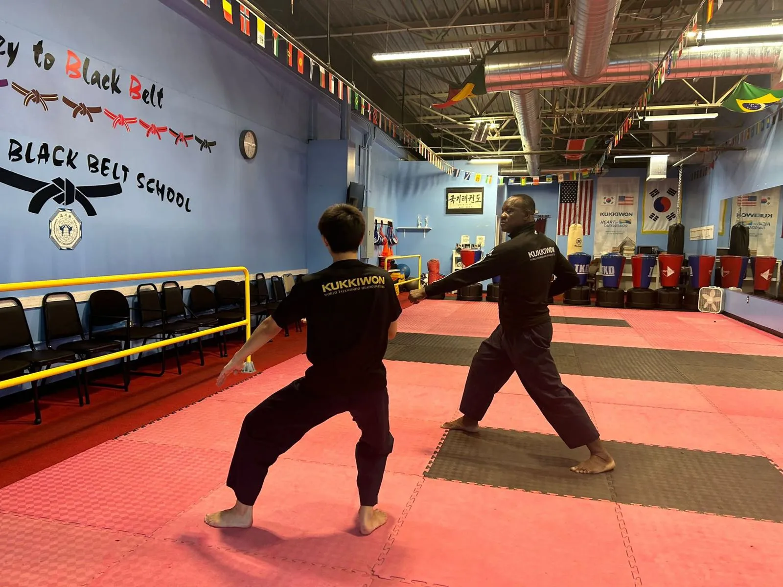 GrandMaster Pius Ilukhor teaching a student one-on-one in Kukkiwon uniforms at the Master Pius Martial Arts dojang in Sandy Springs