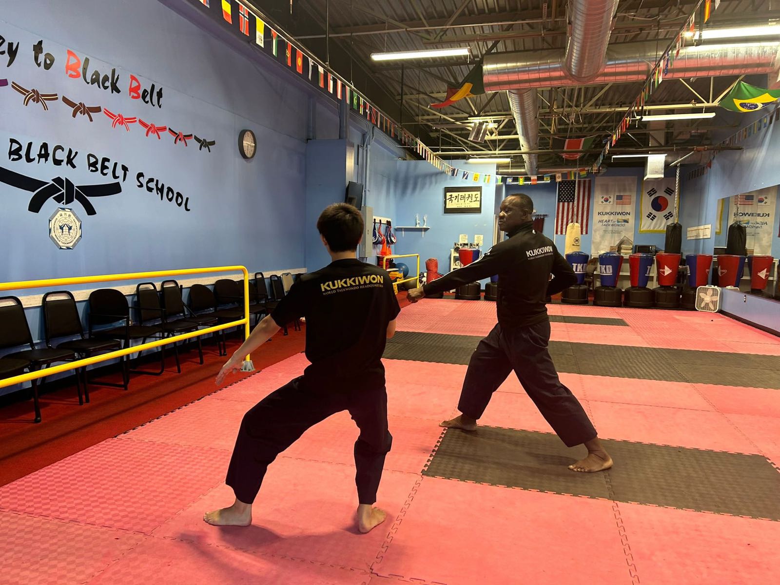 GrandMaster Pius Ilukhor teaching a student one-on-one in Kukkiwon uniforms at the Master Pius Martial Arts dojang in Sandy Springs