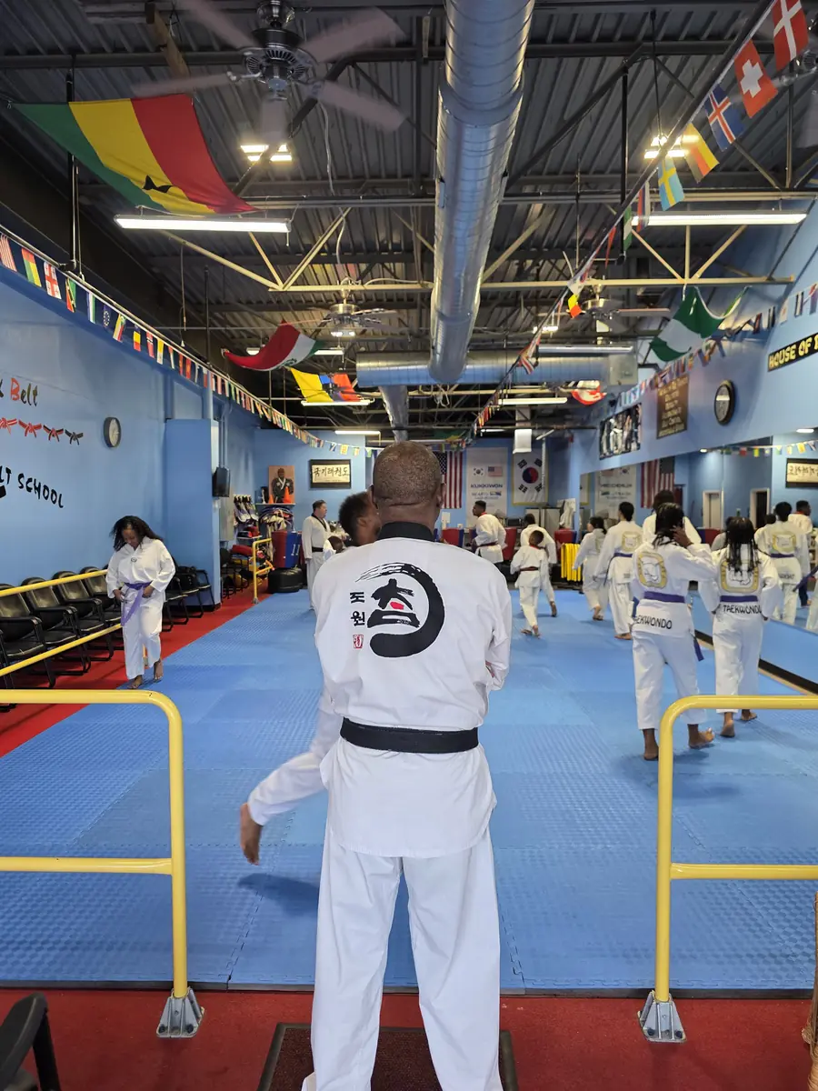 GrandMaster Pius leading a full adult Taekwondo class on the dojang floor